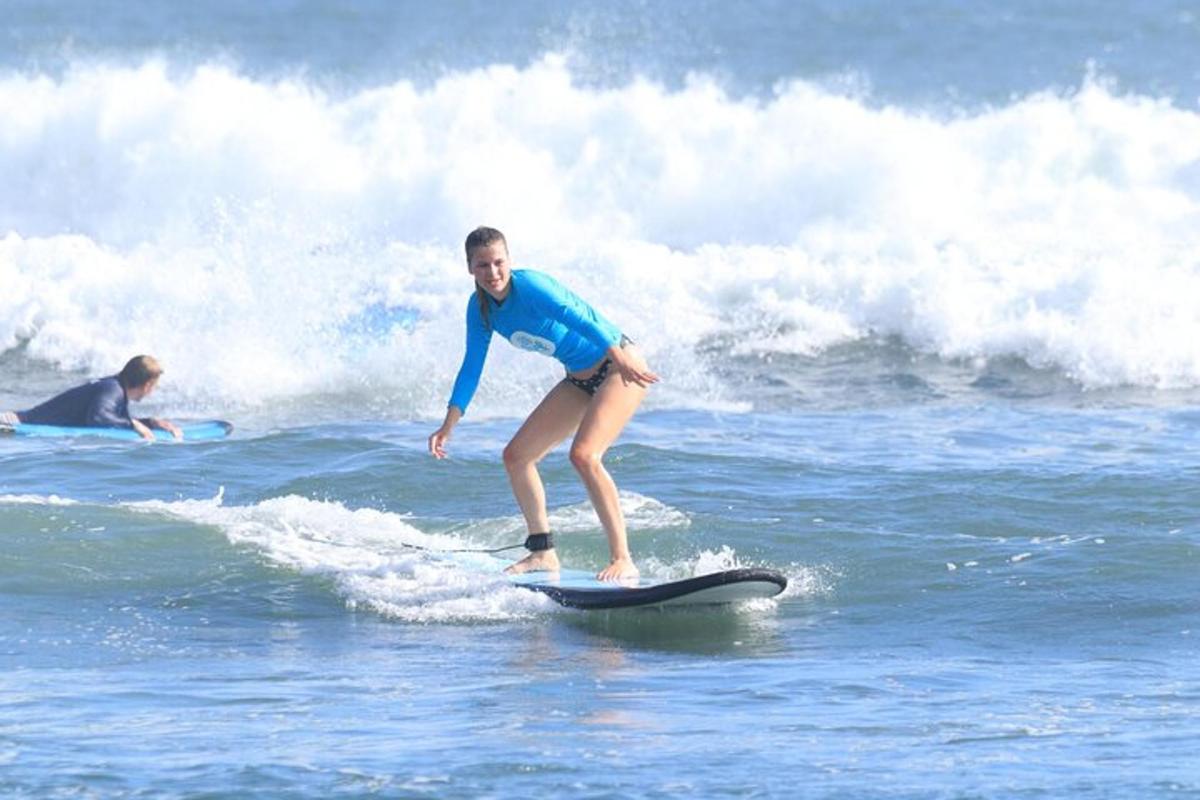 Una mujer montando una ola en una tabla de surf en el océano
