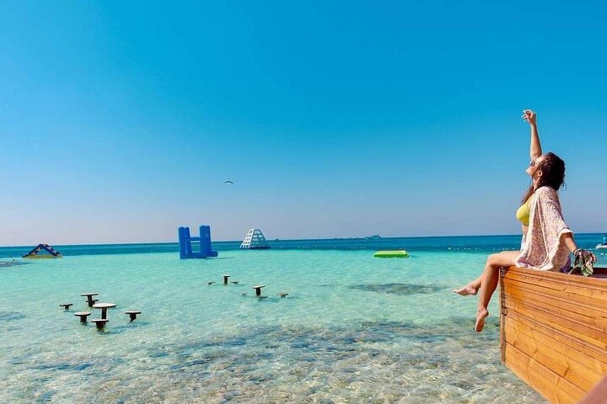 a woman sitting on a ledge on the beach