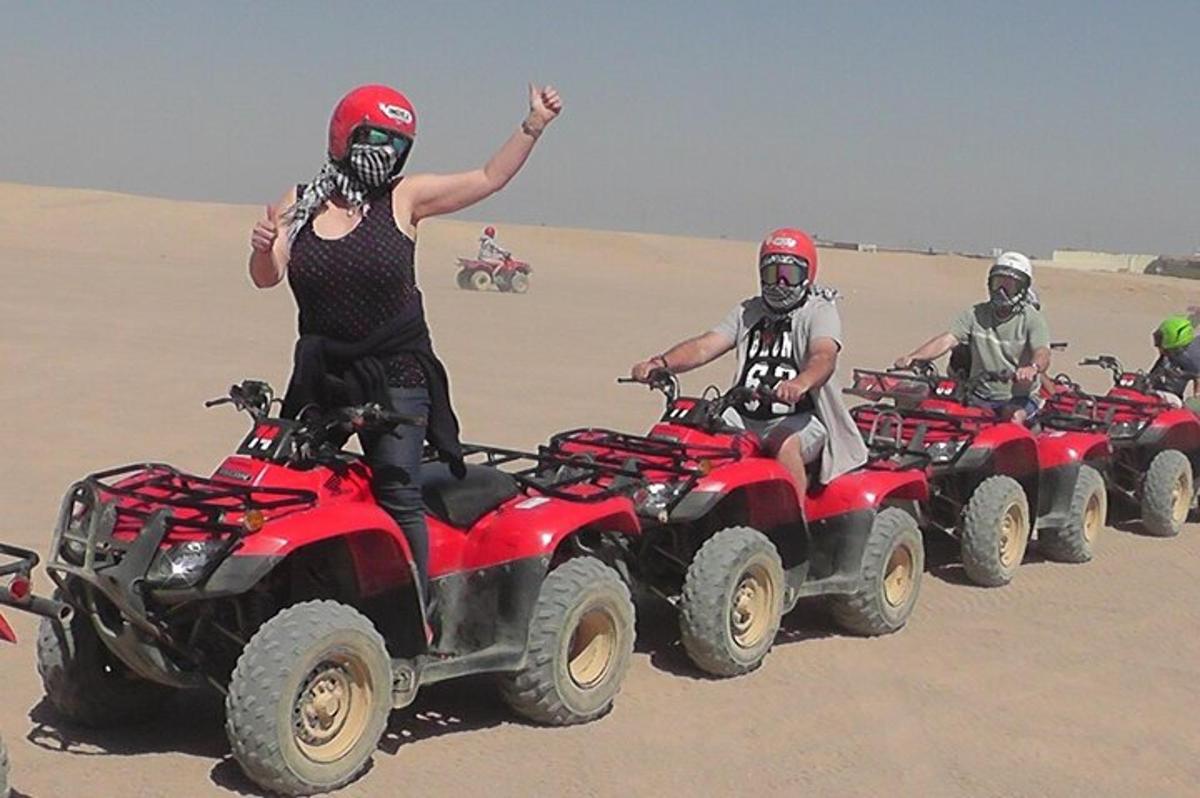 un grup de oameni care călătoresc cu ATV-uri în deșert
