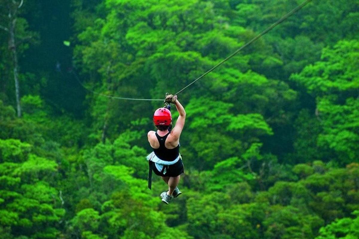 a woman is zip lining in a forest