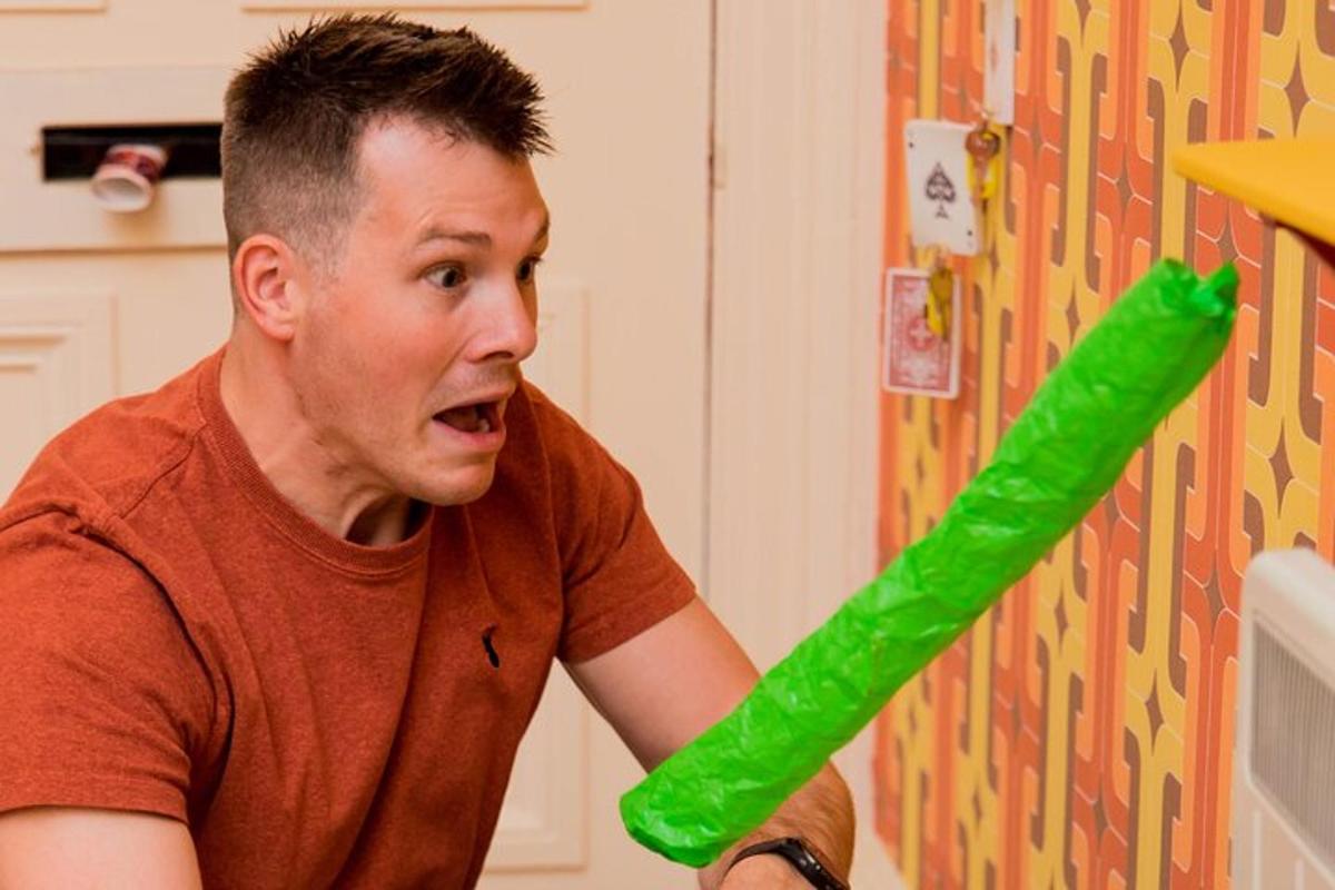 un uomo tiene in mano un tubo di plastica verde