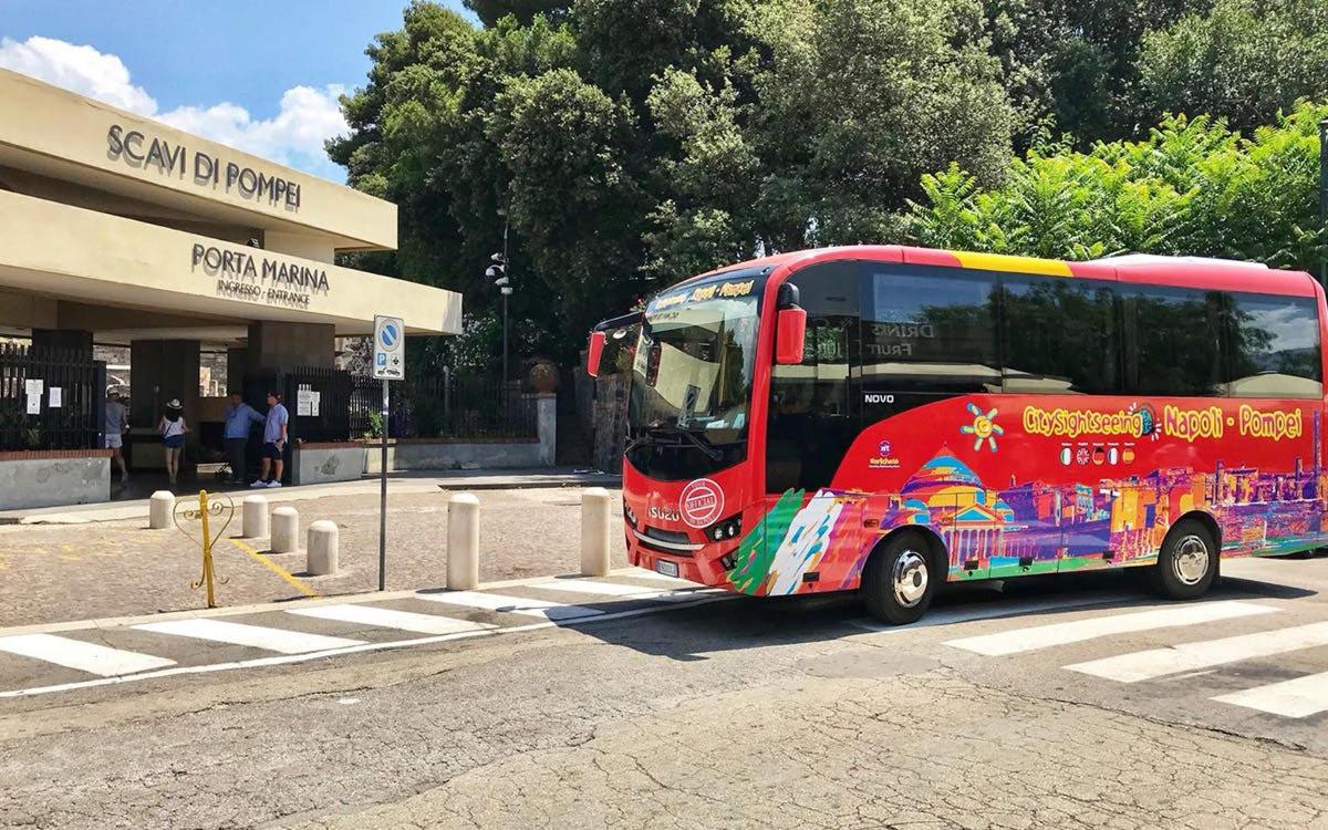un autobuz roșu parcat în fața unei clădiri