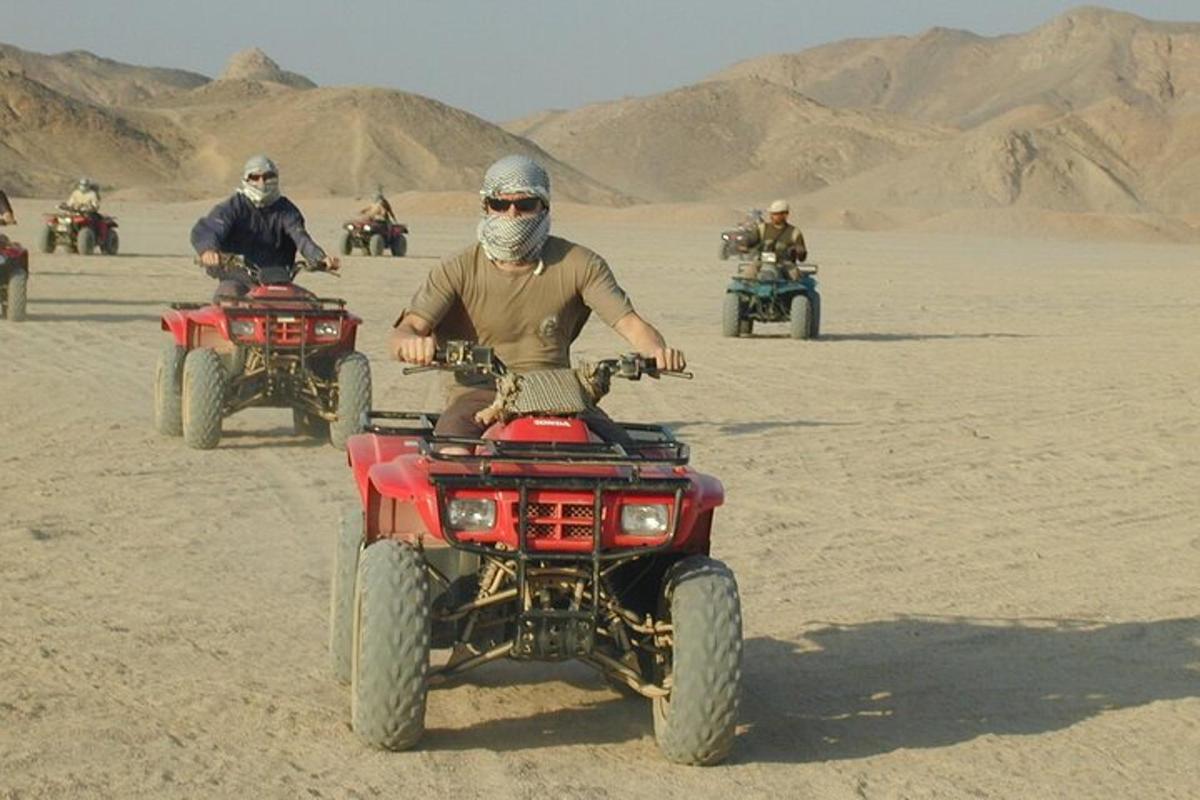 un home en un quad al desert