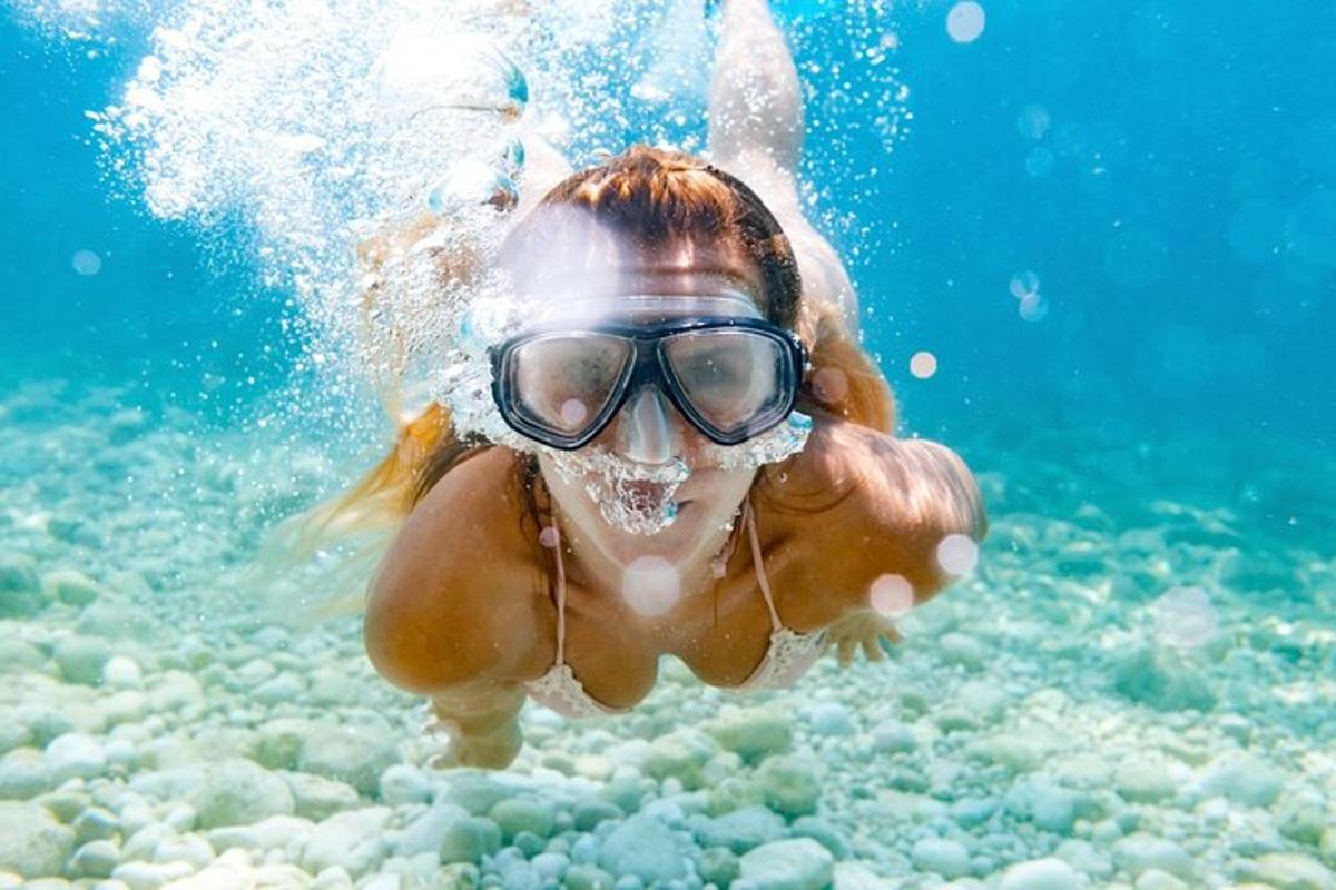 a woman swimming in the water with a mask on