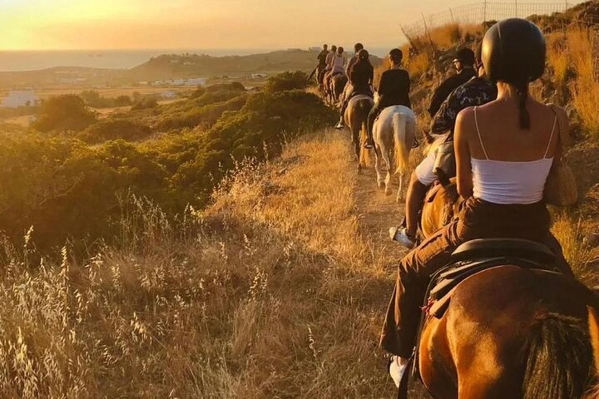 a group of people riding horses down a hill