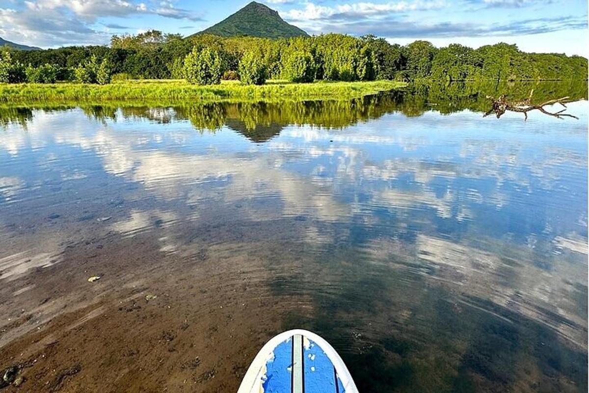 una tavola da paddle in acqua con una montagna sullo sfondo