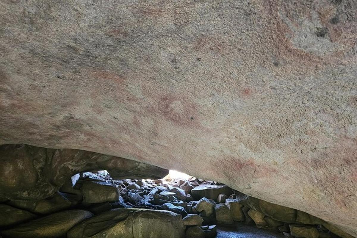 ein Gemälde einer Höhle mit einem Fluss darin