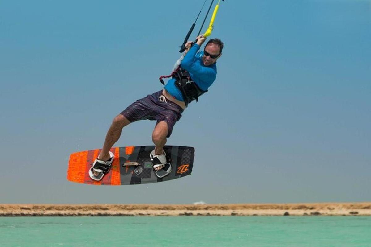 Un hombre en una tabla en el aire sobre el agua.