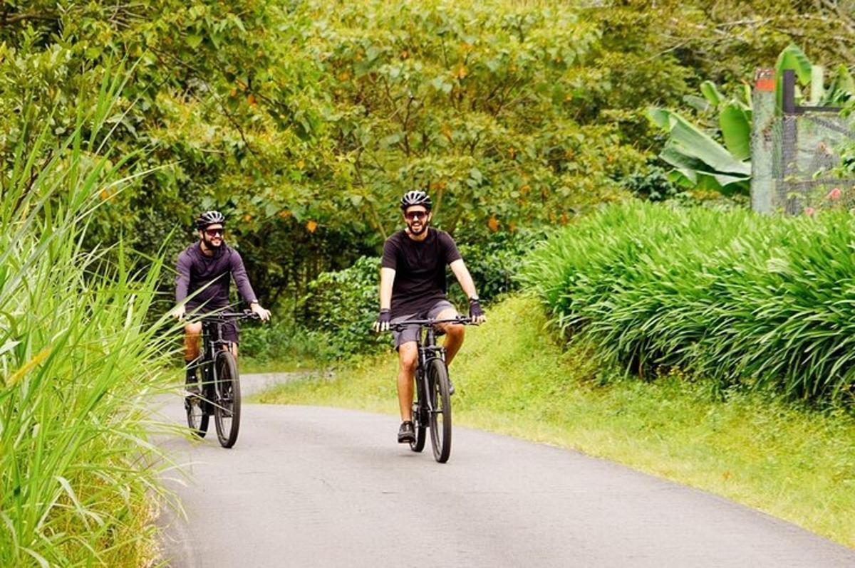 two people riding bikes down a road