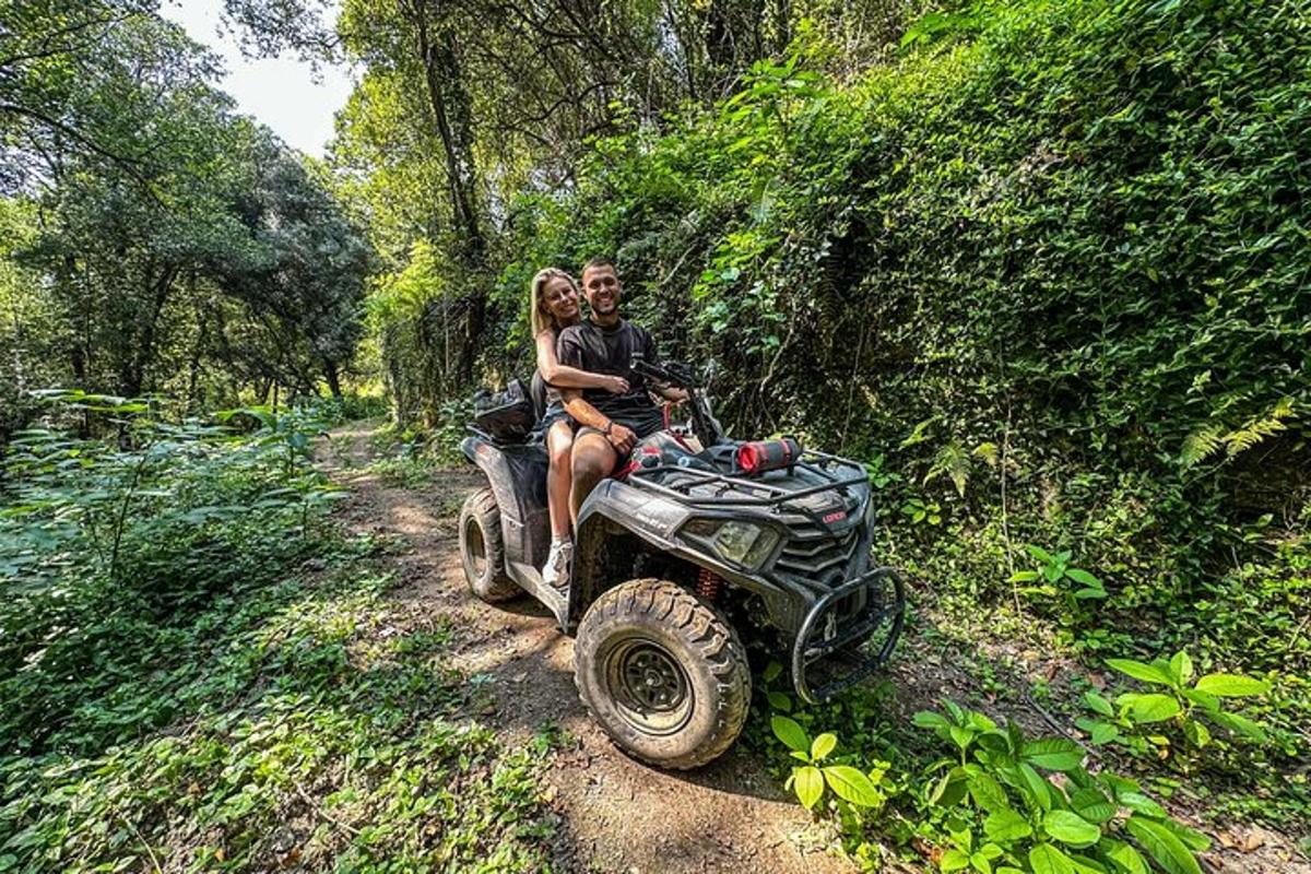 a man and woman riding on a wheeler on a trail
