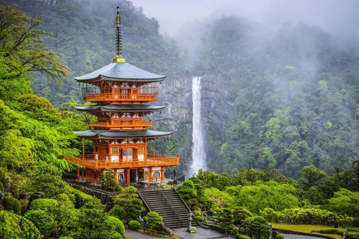 a pagoda with a waterfall in the background