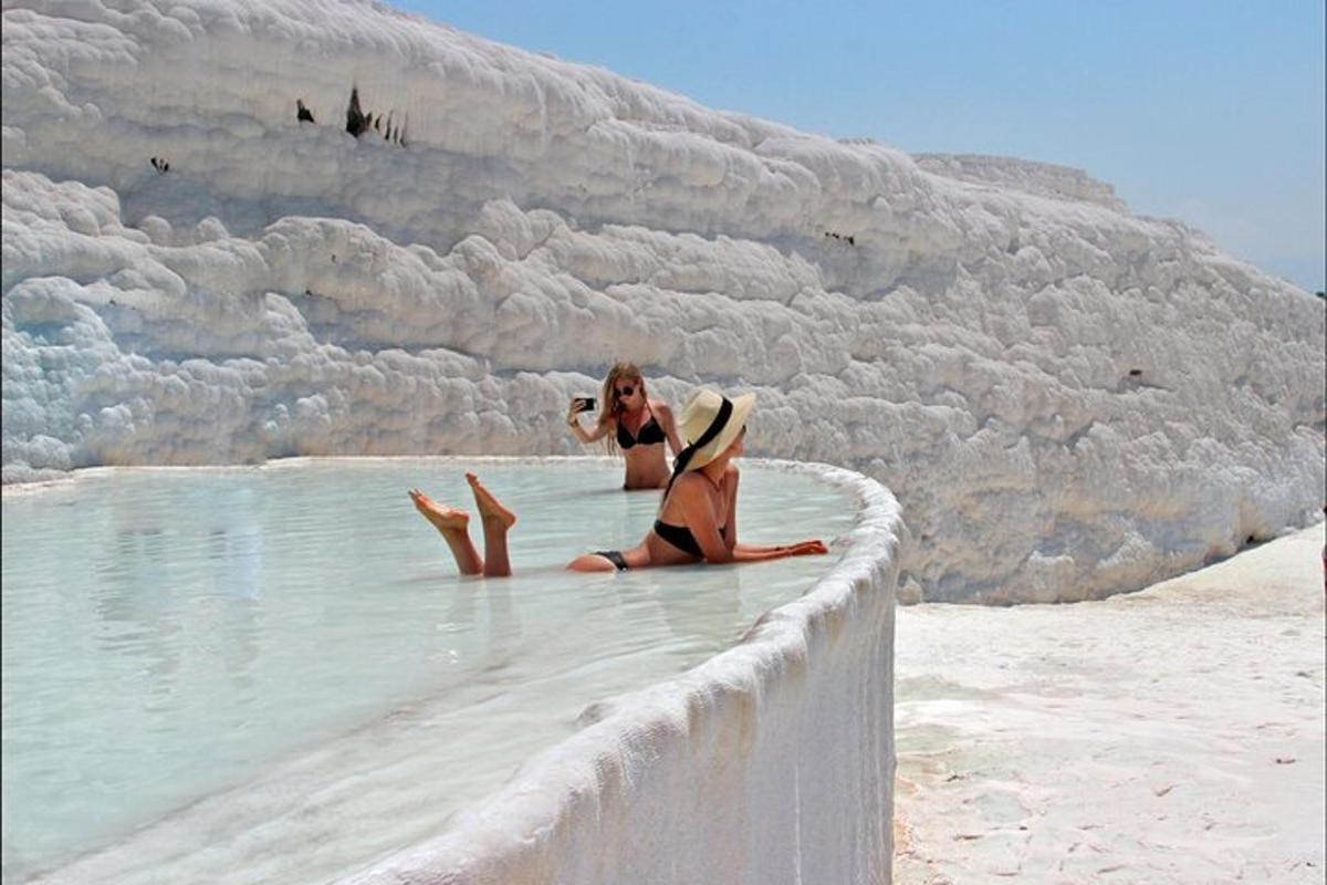 dos mujeres sentadas en el agua en la playa