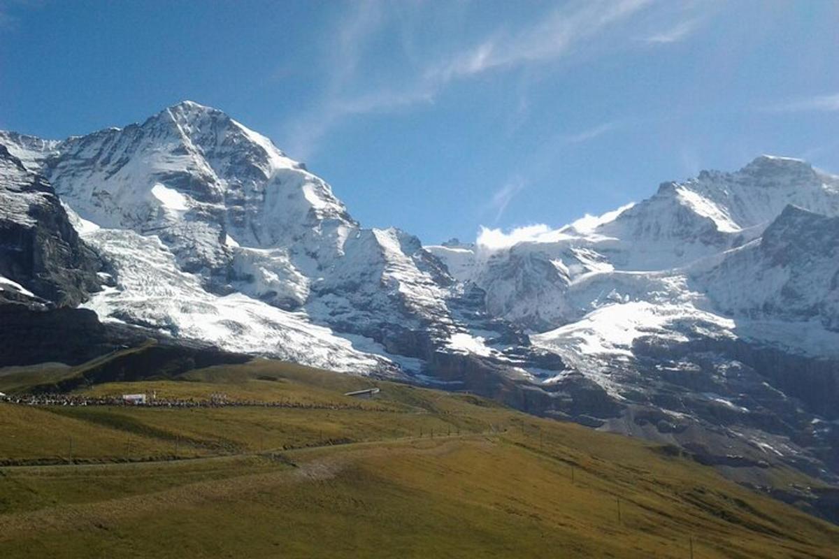 una montagna coperta di neve con un campo di fronte