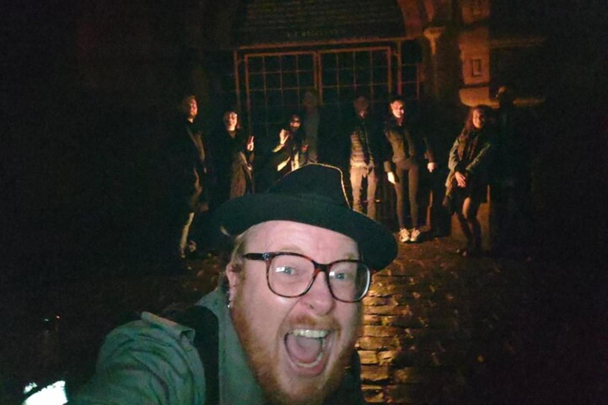 un home amb barret i ulleres davant d'un grup de persones