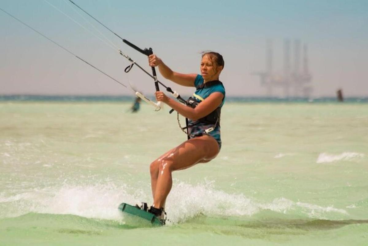 o femeie pe o placă de surf ținându-se de o frânghie