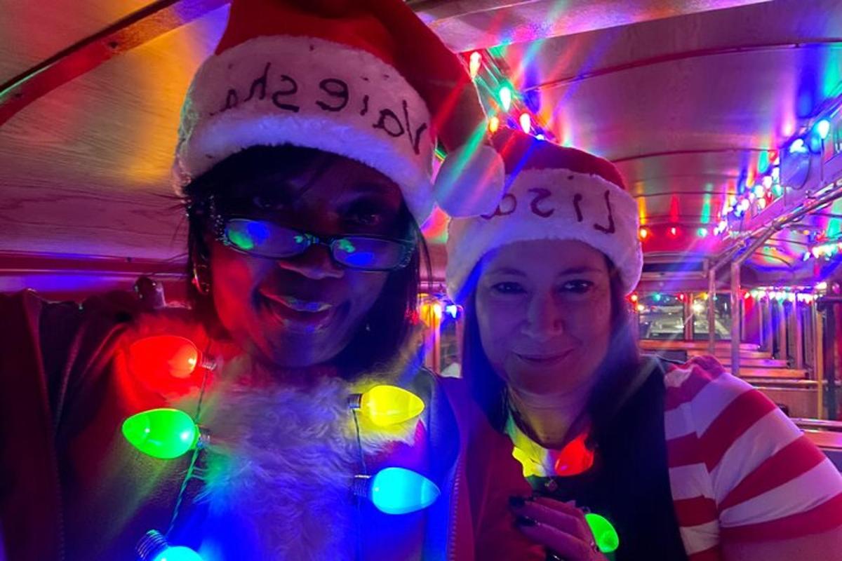 two women wearing santa hats in a room with lights