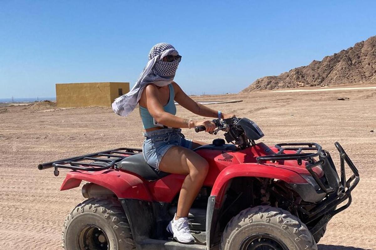 a woman riding a quad bike in the desert