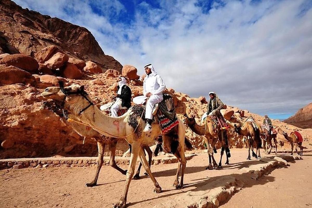 Un grupo de personas montando camellos en el desierto.