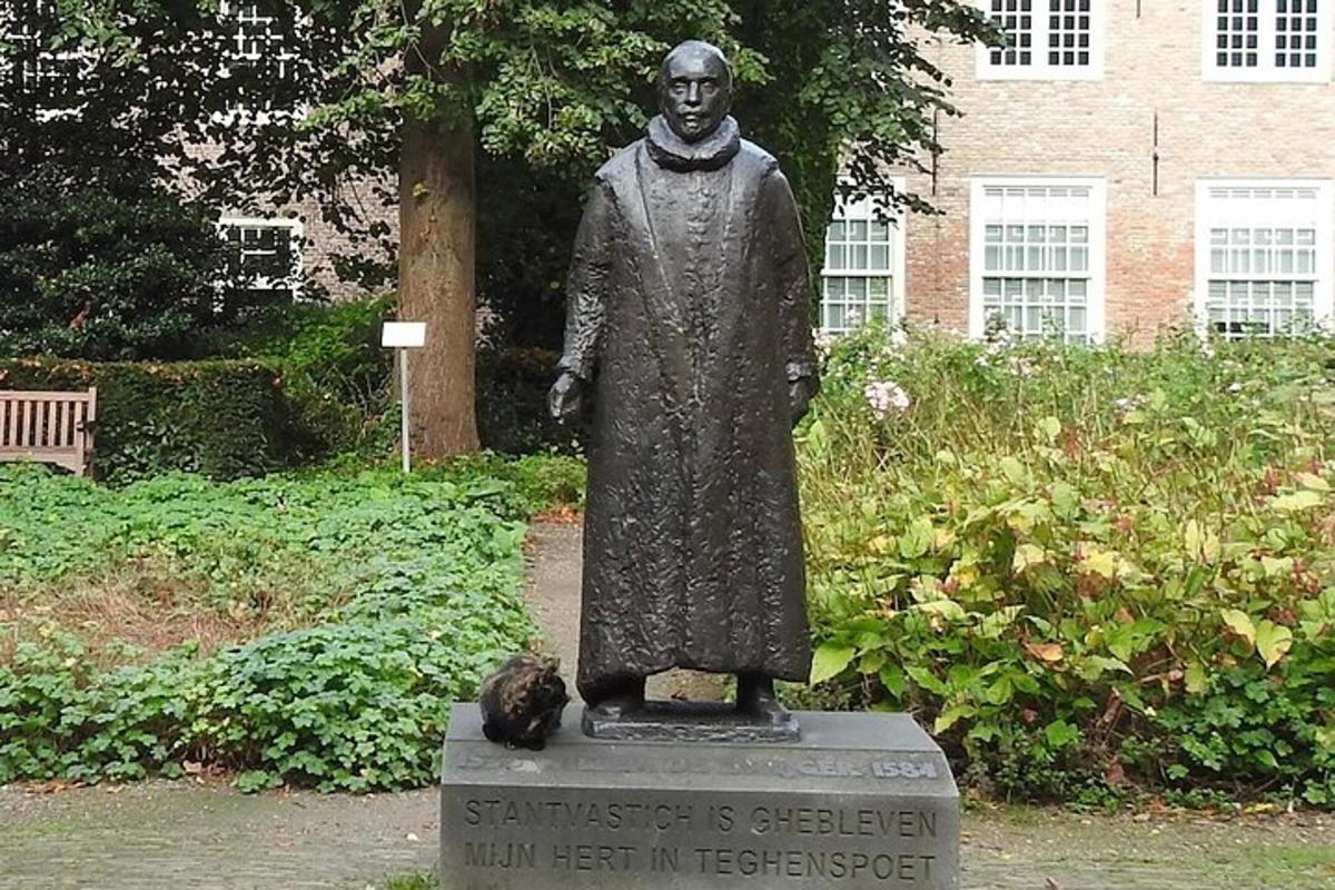 una statua di un uomo con un gatto seduto accanto ad essa