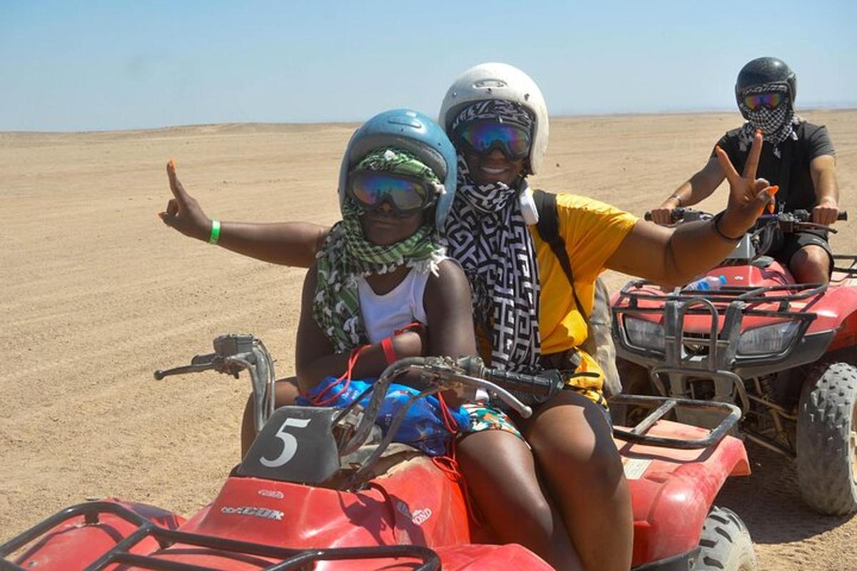 tre persone in sella a quad nel deserto
