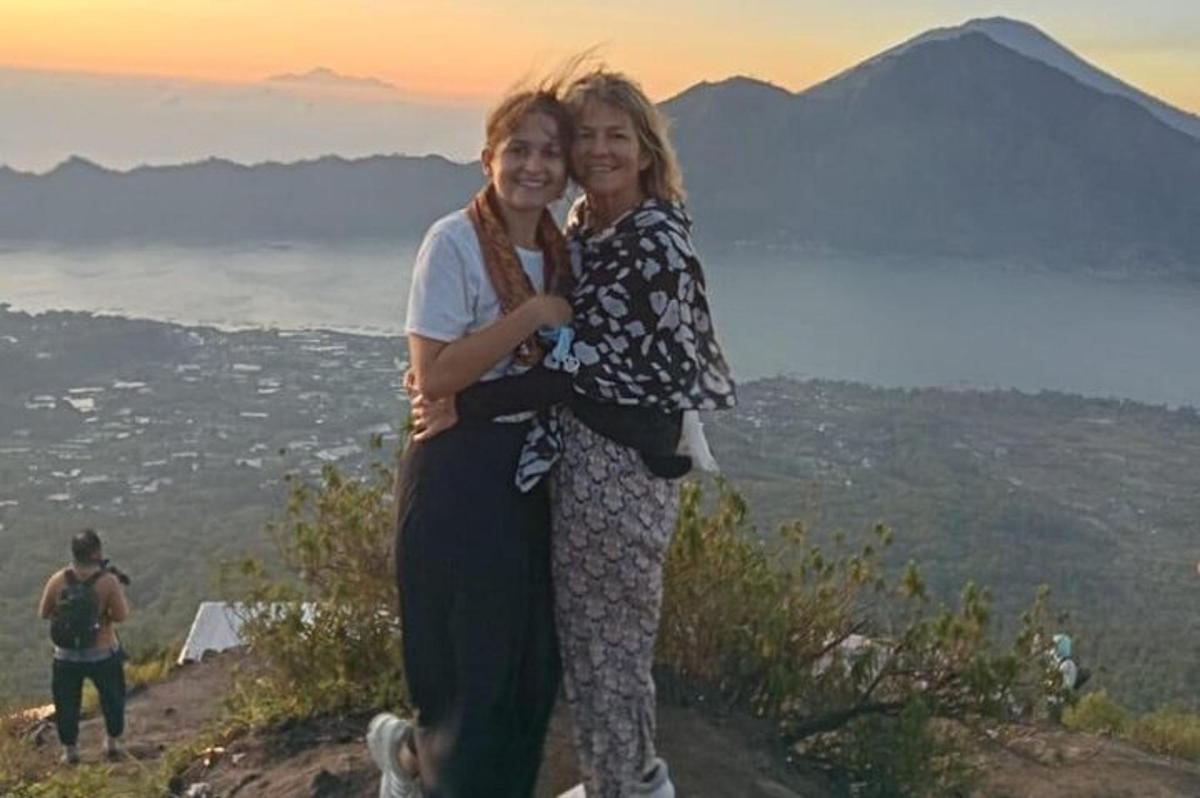 dos mujeres de pie en la cima de una montaña