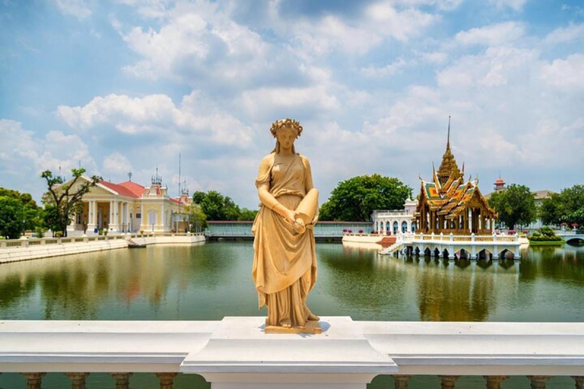 una estatua de una mujer parada frente a un cuerpo de agua