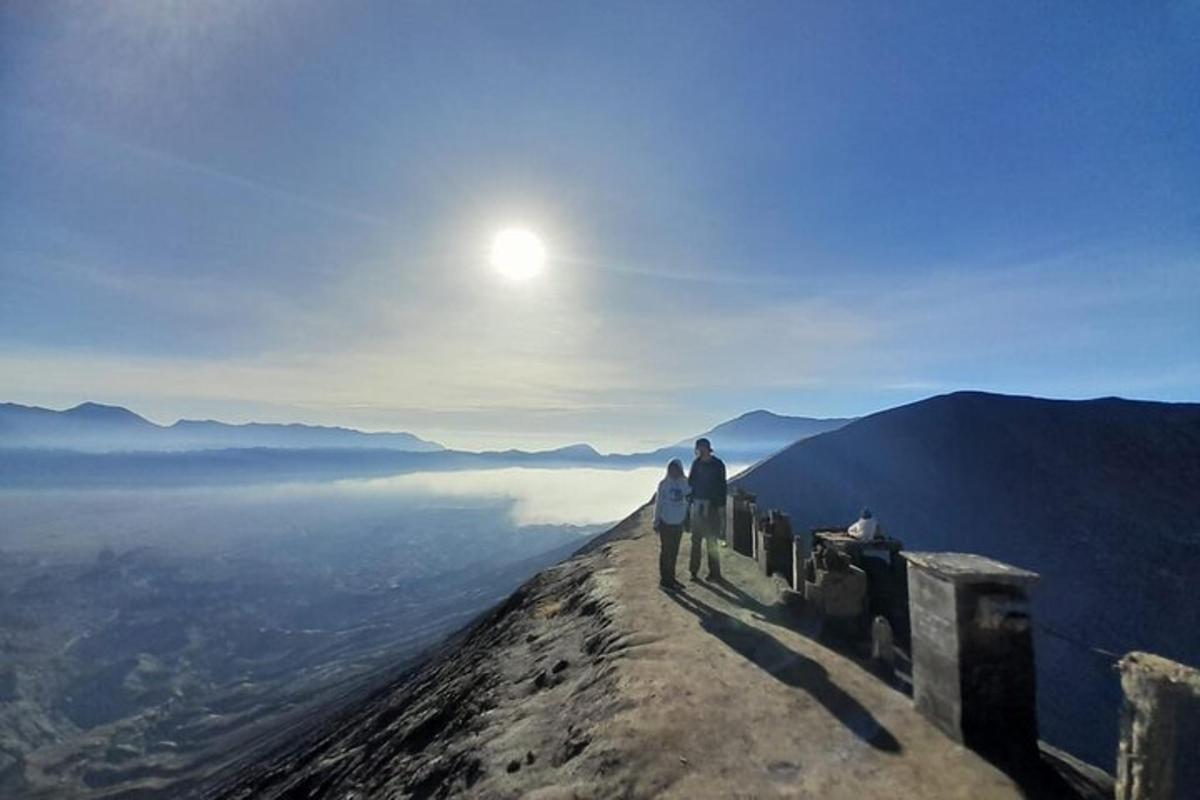 two people standing on top of a mountain looking at the view