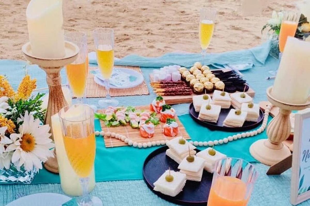 et blått bord med mat og drikke på en strand