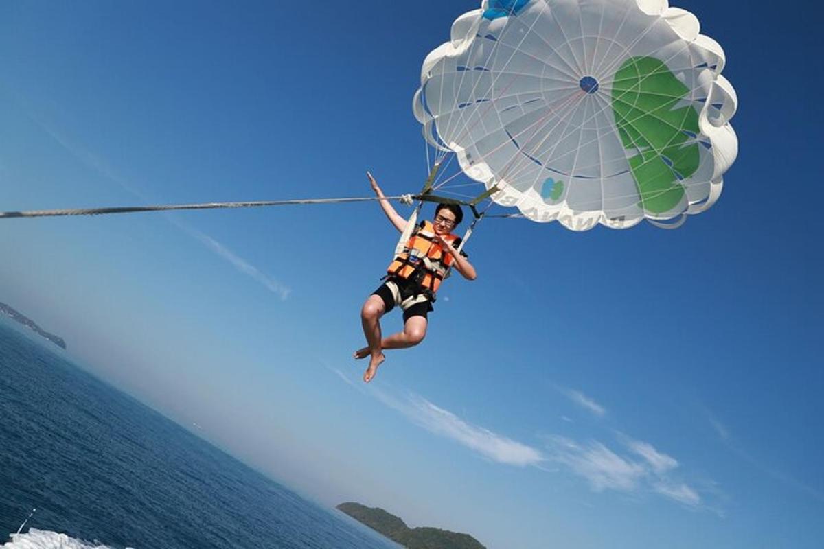 Muž visí na padáku nad vodou