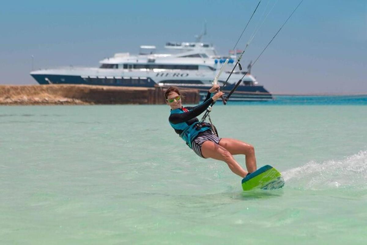 una donna su una tavola da surf in acqua con una barca