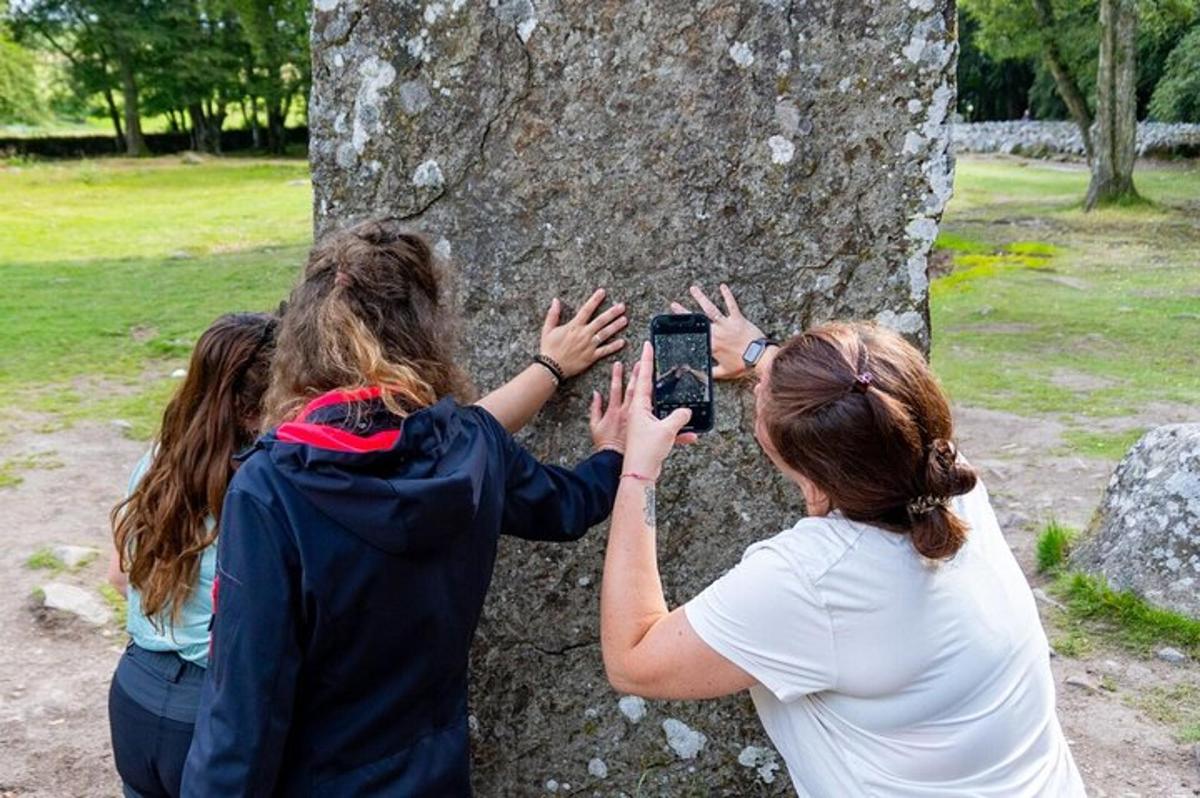 two women taking a picture of a tree
