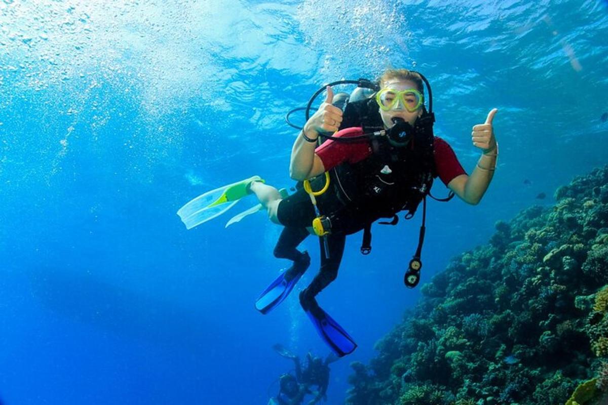 oseba, ki med potapljanjem v oceanu pokaže palec gor