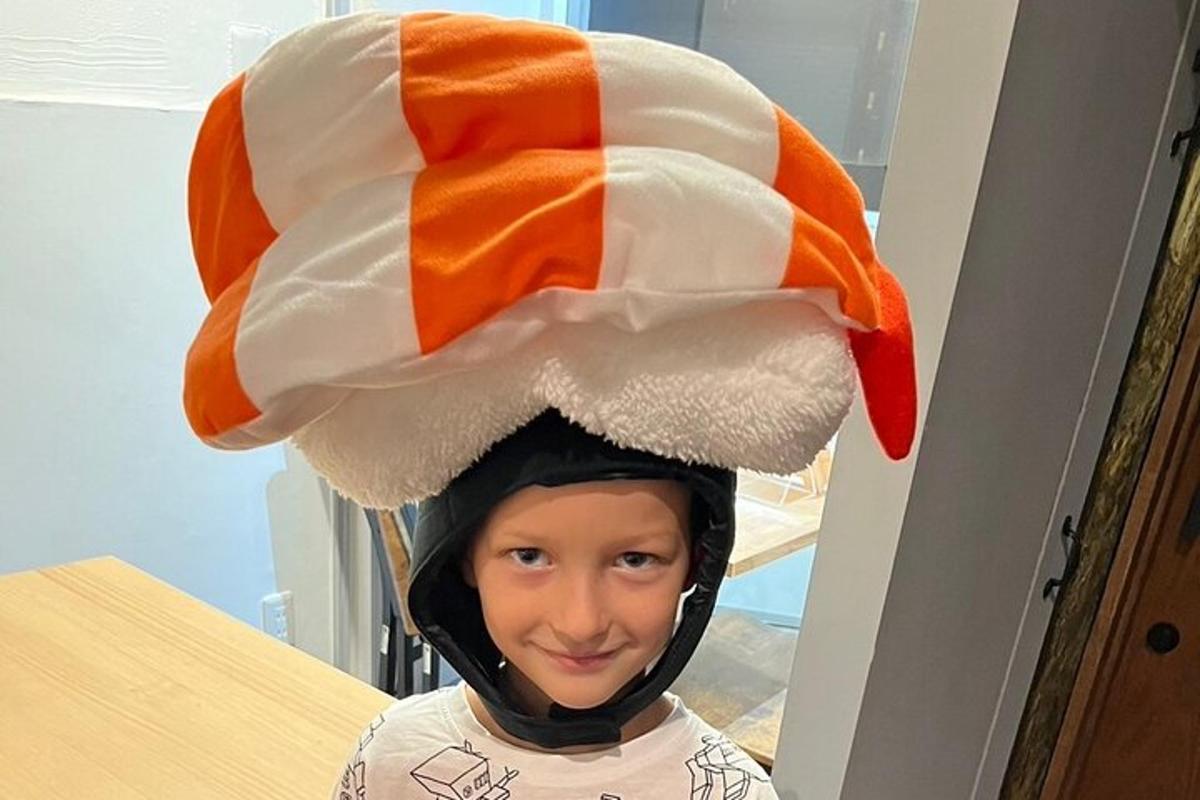 a young boy wearing an orange and white hat
