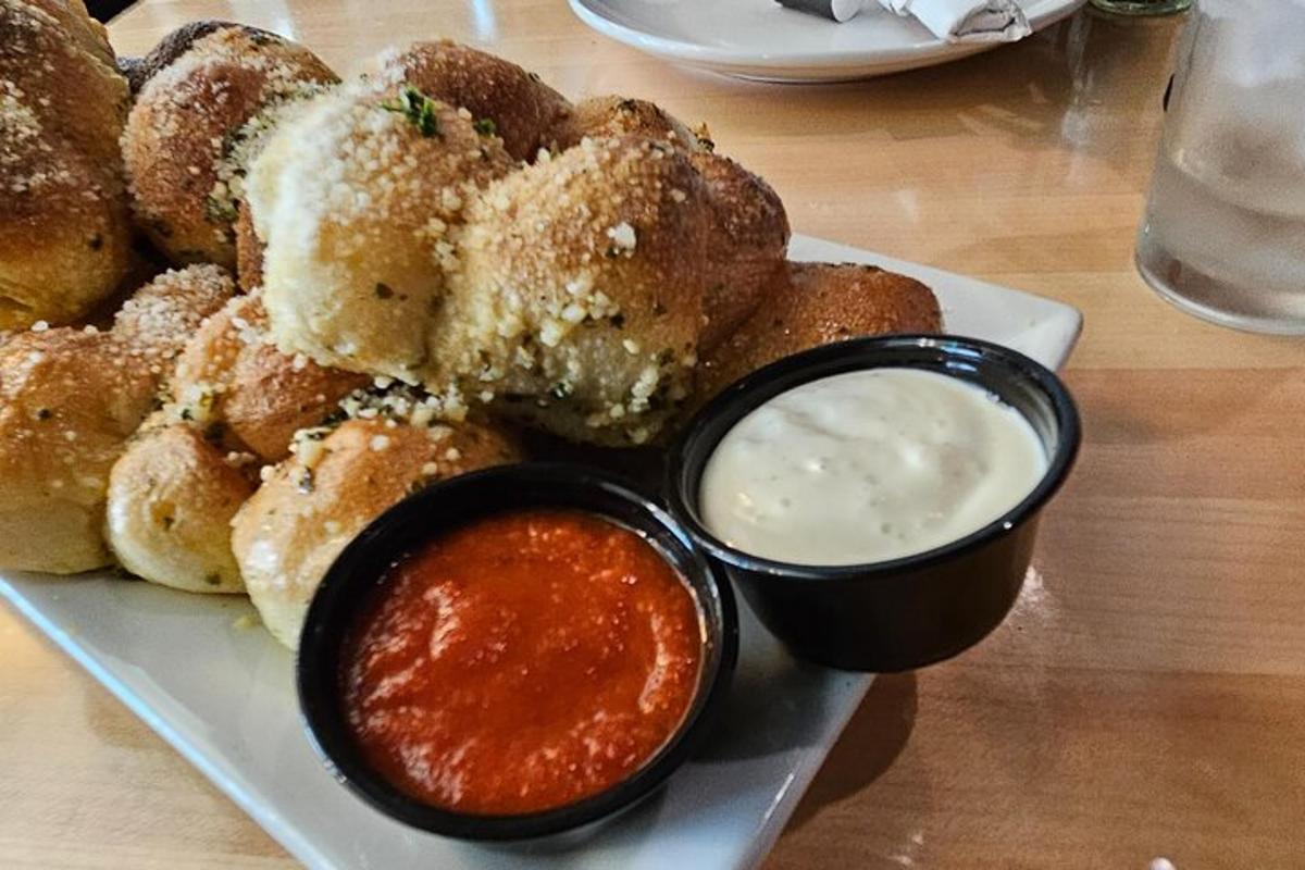 a plate of onion rings with dipping sauce on a table