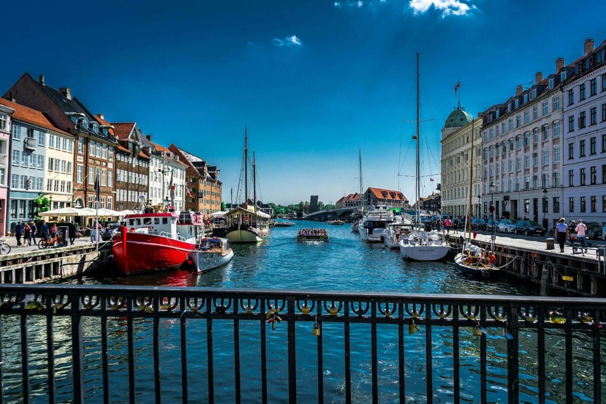 un gruppo di barche attraccate in un fiume con edifici
