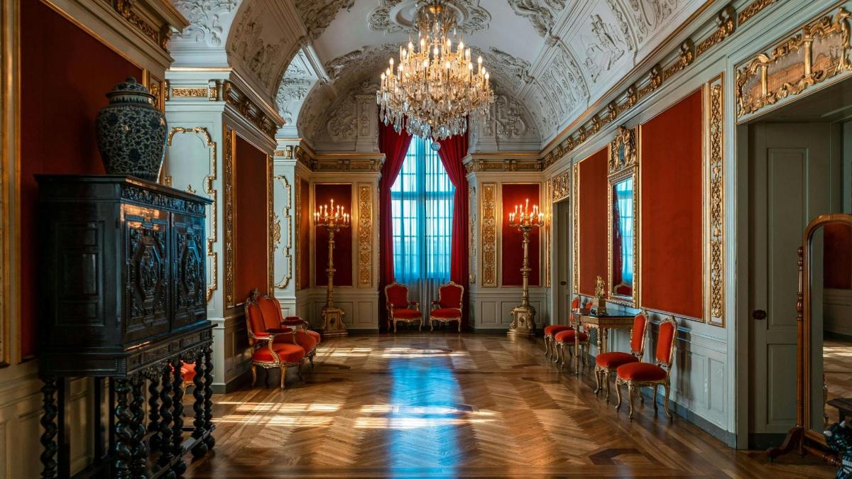una grande stanza con sedie rosse e un lampadario