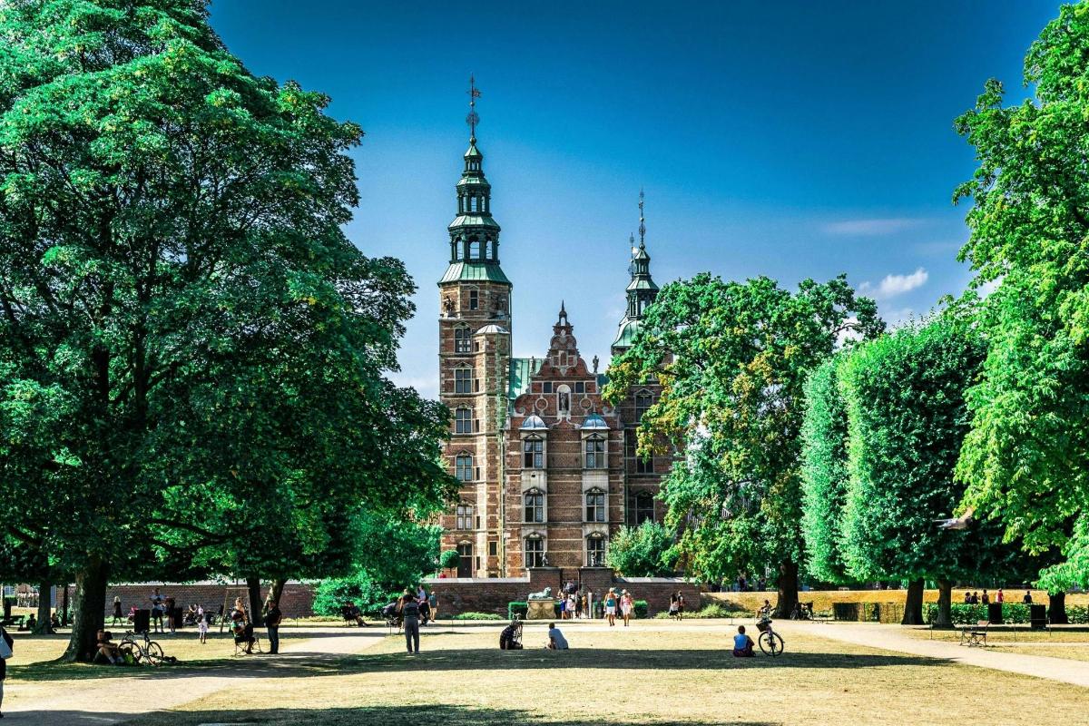 un grande edificio con una torre dell'orologio in un parco