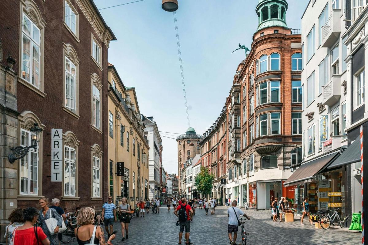 un gruppo di persone che camminano lungo una strada con edifici