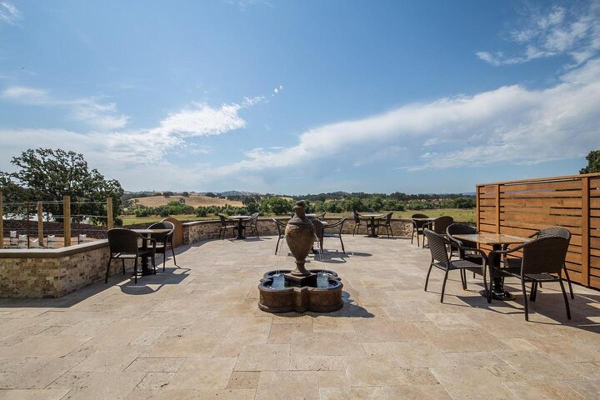a patio with a fountain and tables and chairs