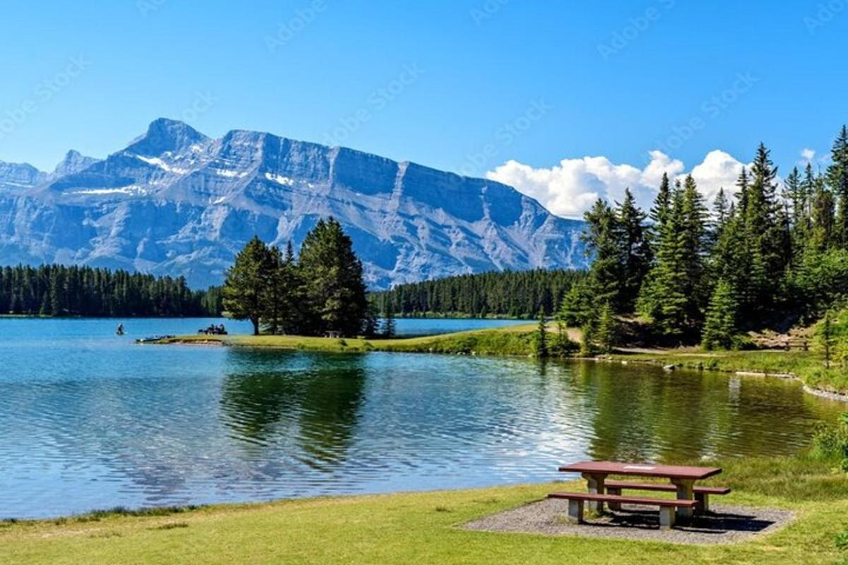 a picnic table next to a lake with a mountain