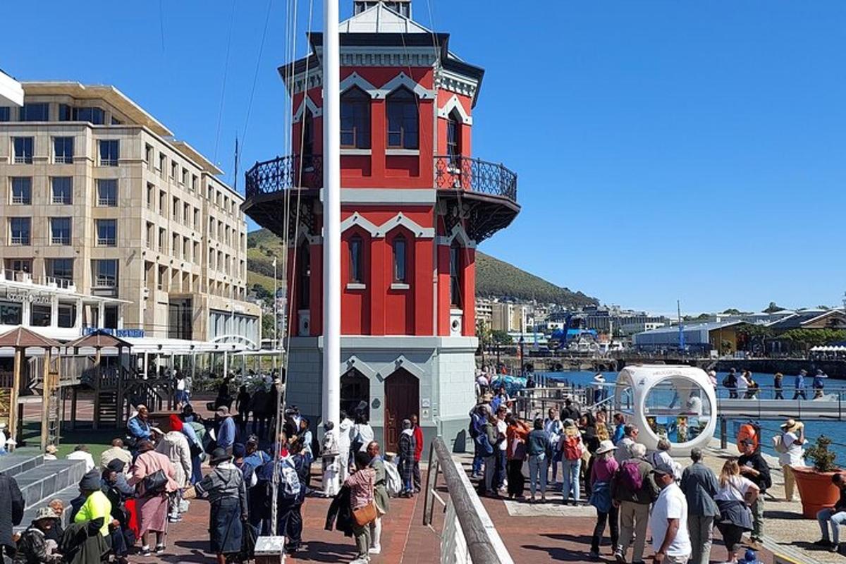 a group of people standing around a red and white tower