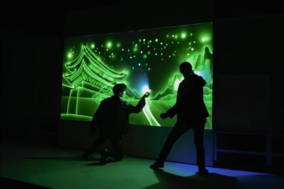 two men standing in front of a painting in a dark room