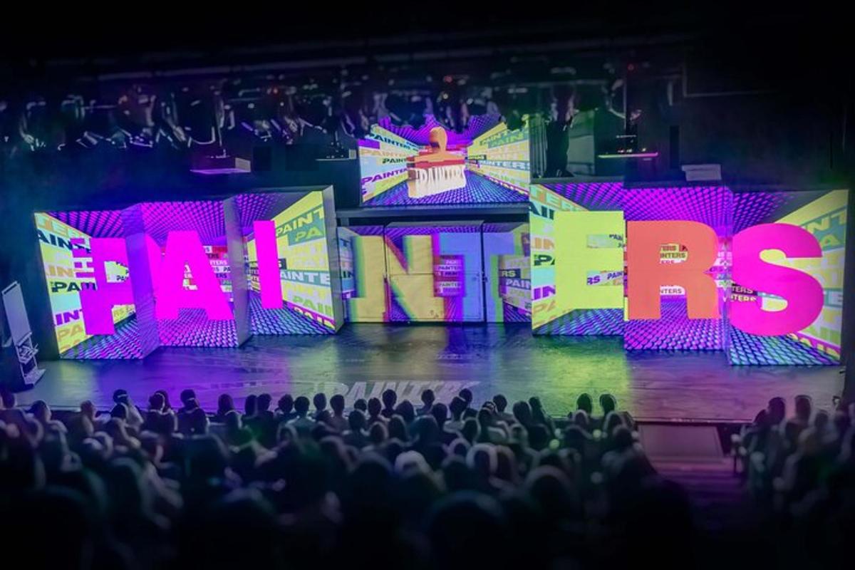 an audience watching a stage with the words maas