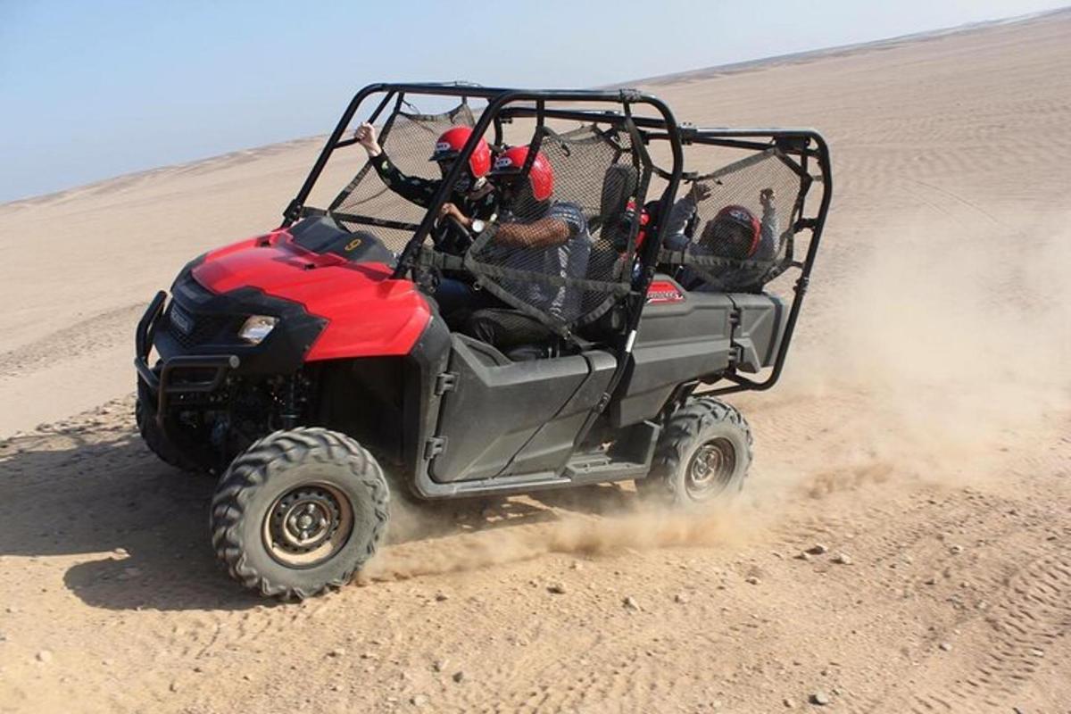 a atv driving through the sand in the desert