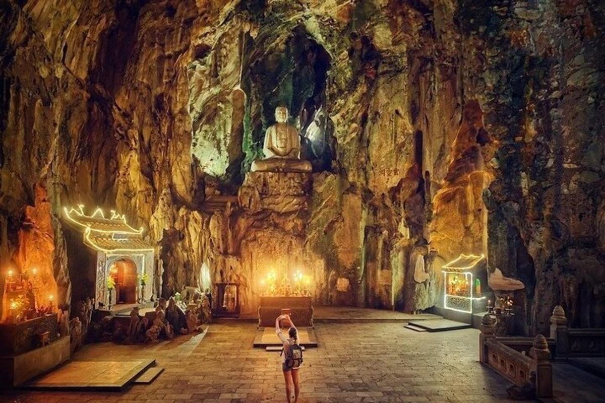 a woman standing in front of a room in a cave