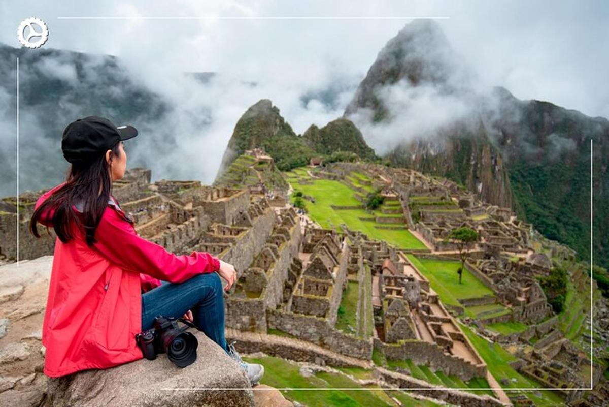 a woman sitting on a rock with a camera at the ruins