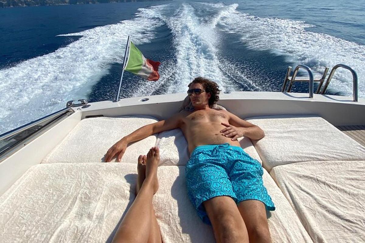 Un hombre tendido en la parte trasera de un barco