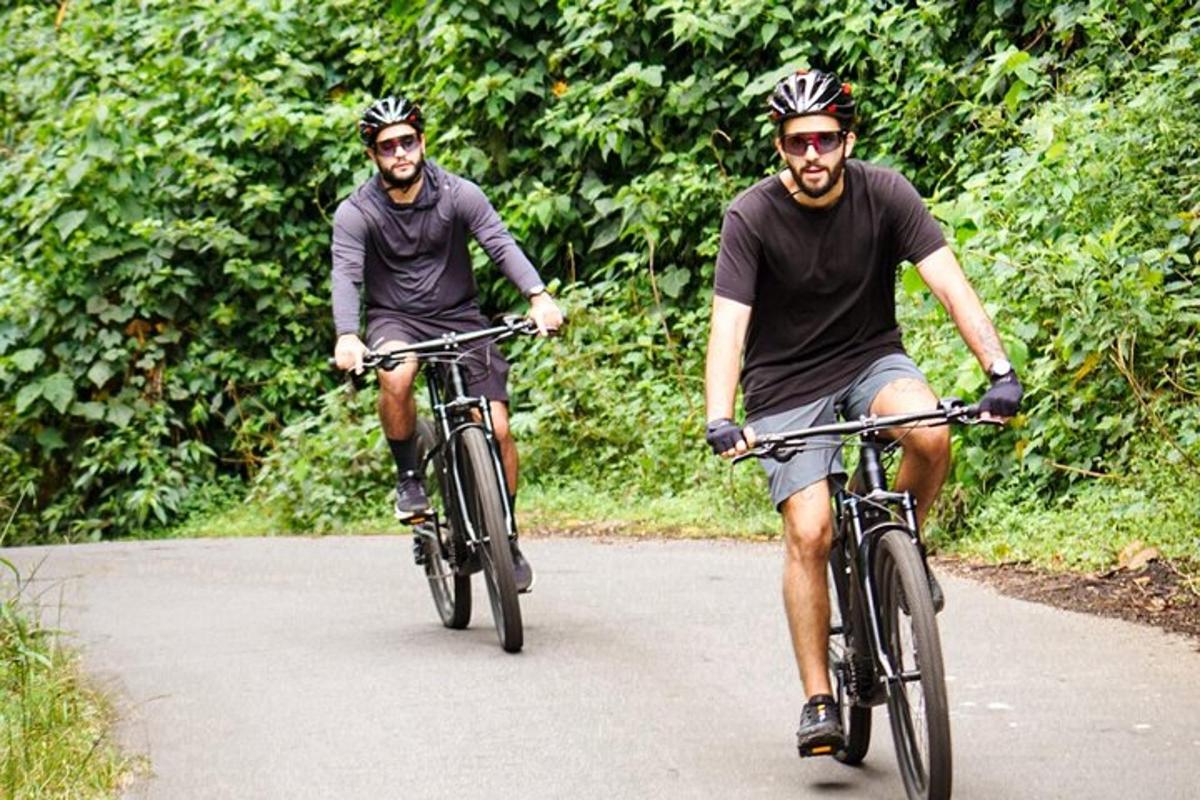 two men riding bikes down a road