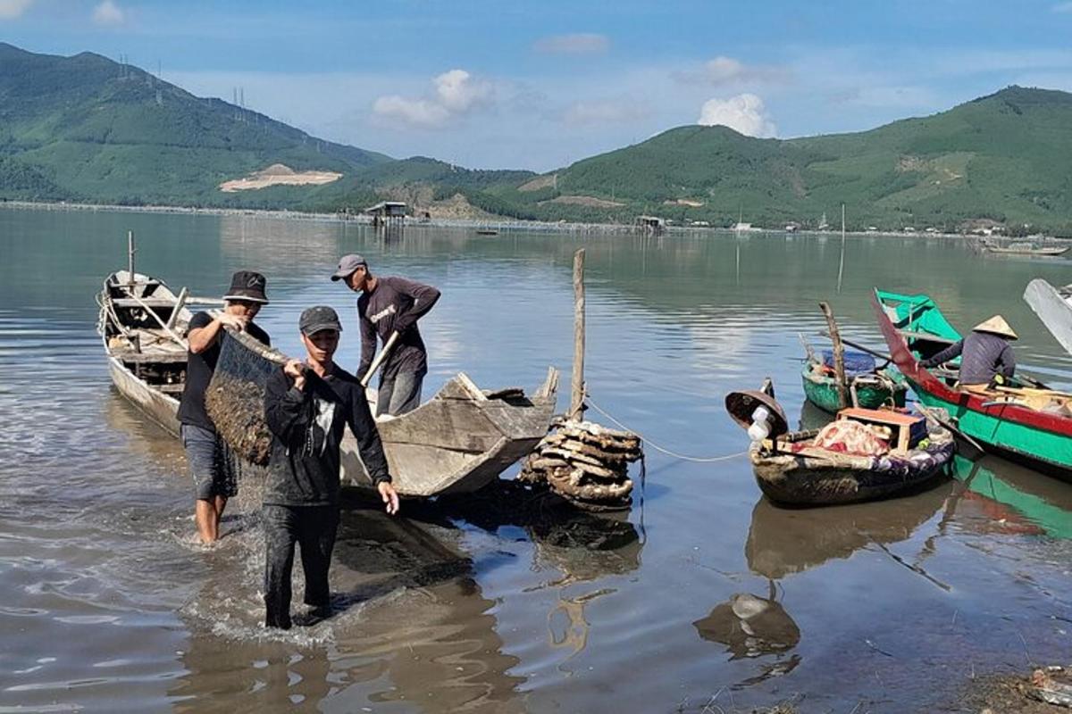 un gruppo di persone in piedi nell'acqua accanto a una barca
