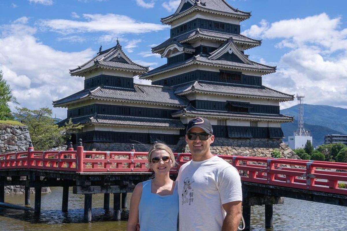 a man and a woman standing in front of a castle